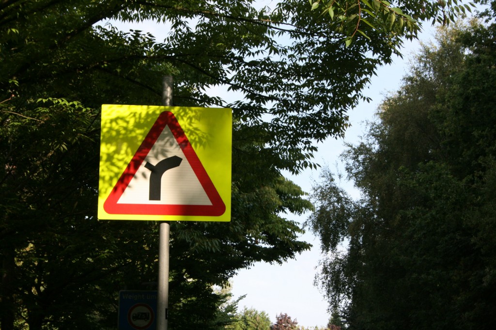 Right hand bend ahead sign with yellow backboard